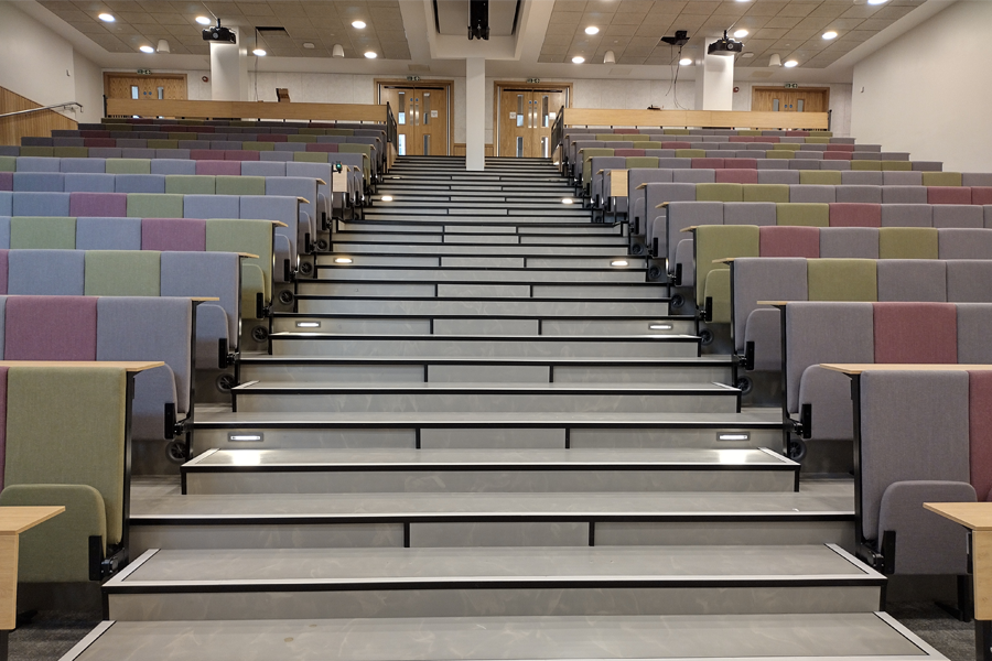 A modern lecture theatre in a muted palette of colours featuring the Scholar seat by Audience Systems